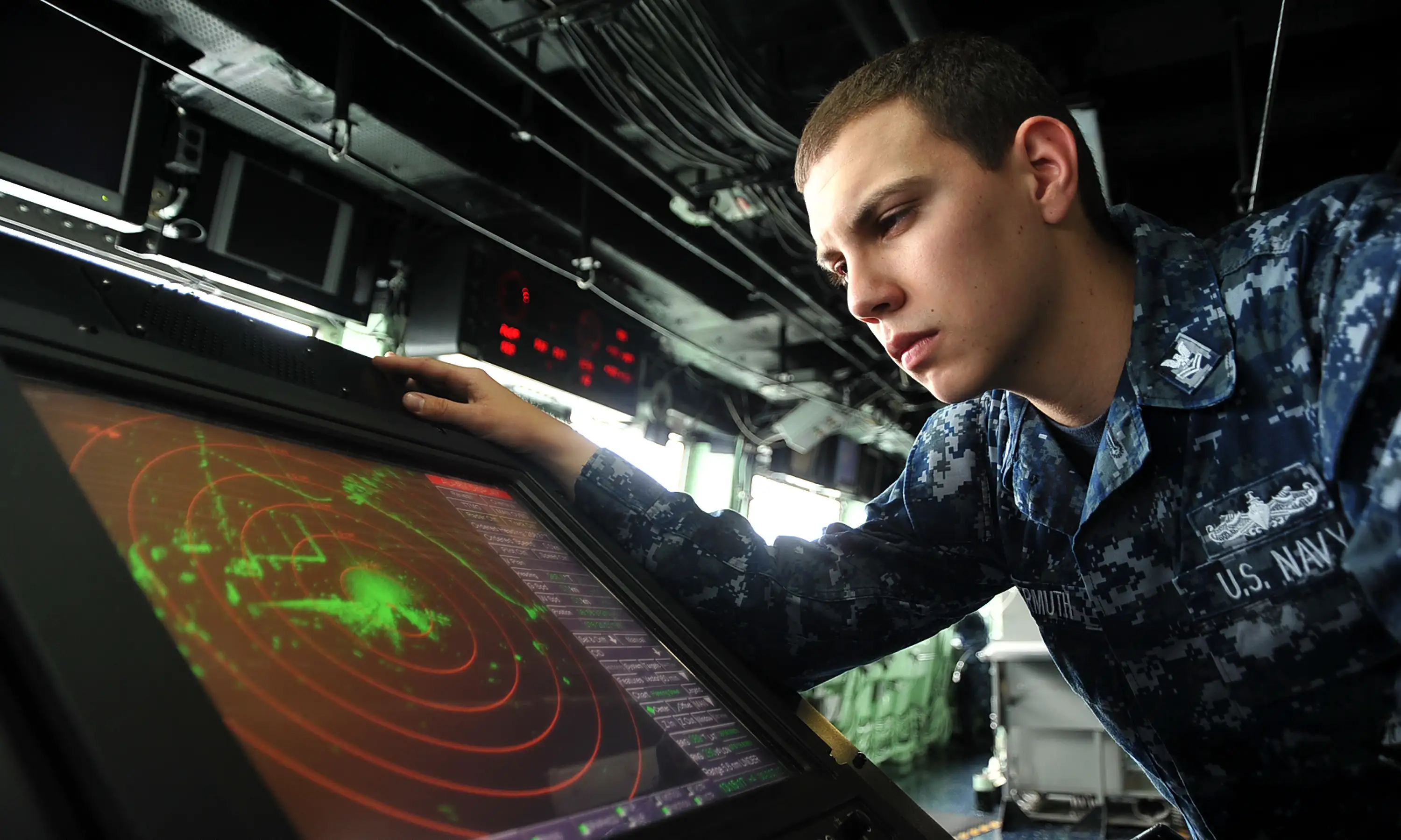 A navy sailor observes a radar plot